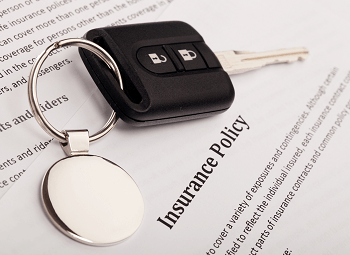 a sheet of paper that reads insurance policy with a set of car keys on top of it